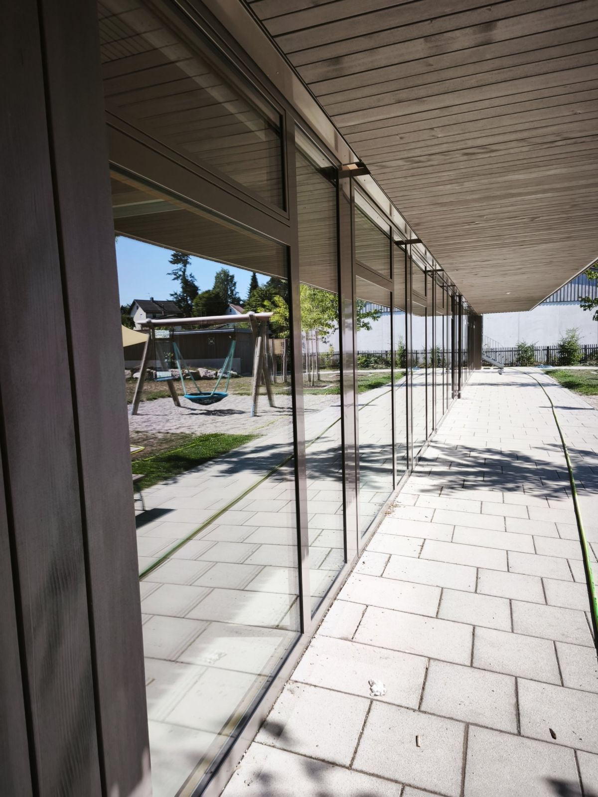 Glasfront entlang eines überdachten Gangs